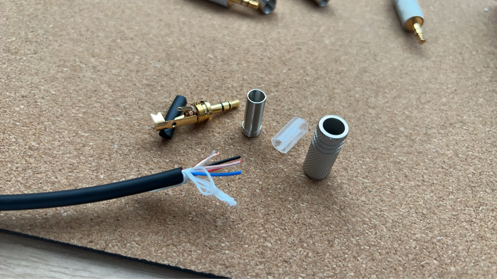 試作中のステレオミニ（3.5mm）ケーブル。分解したプラグのパーツと、外皮を剥いて4本の導体が出た多芯ケーブル